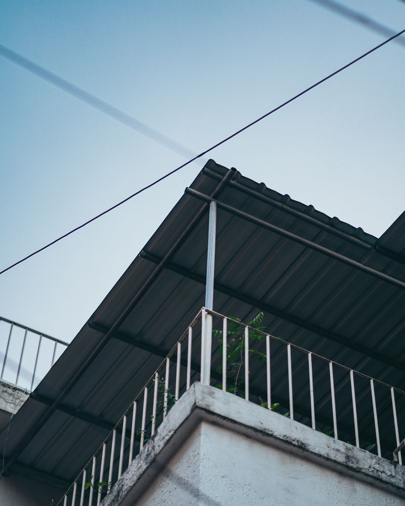 Cobertura metálica e guarda-corpo em área externa de edifício
