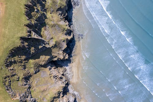 Aerial Photography of Crashing Waves Near Cliff Coast