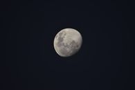A detailed view of the waxing gibbous moon, highlighting its craters against a dark night sky.