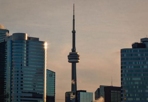 Free A stunning view of the Toronto skyline with the iconic CN Tower during sunset. Stock Photo