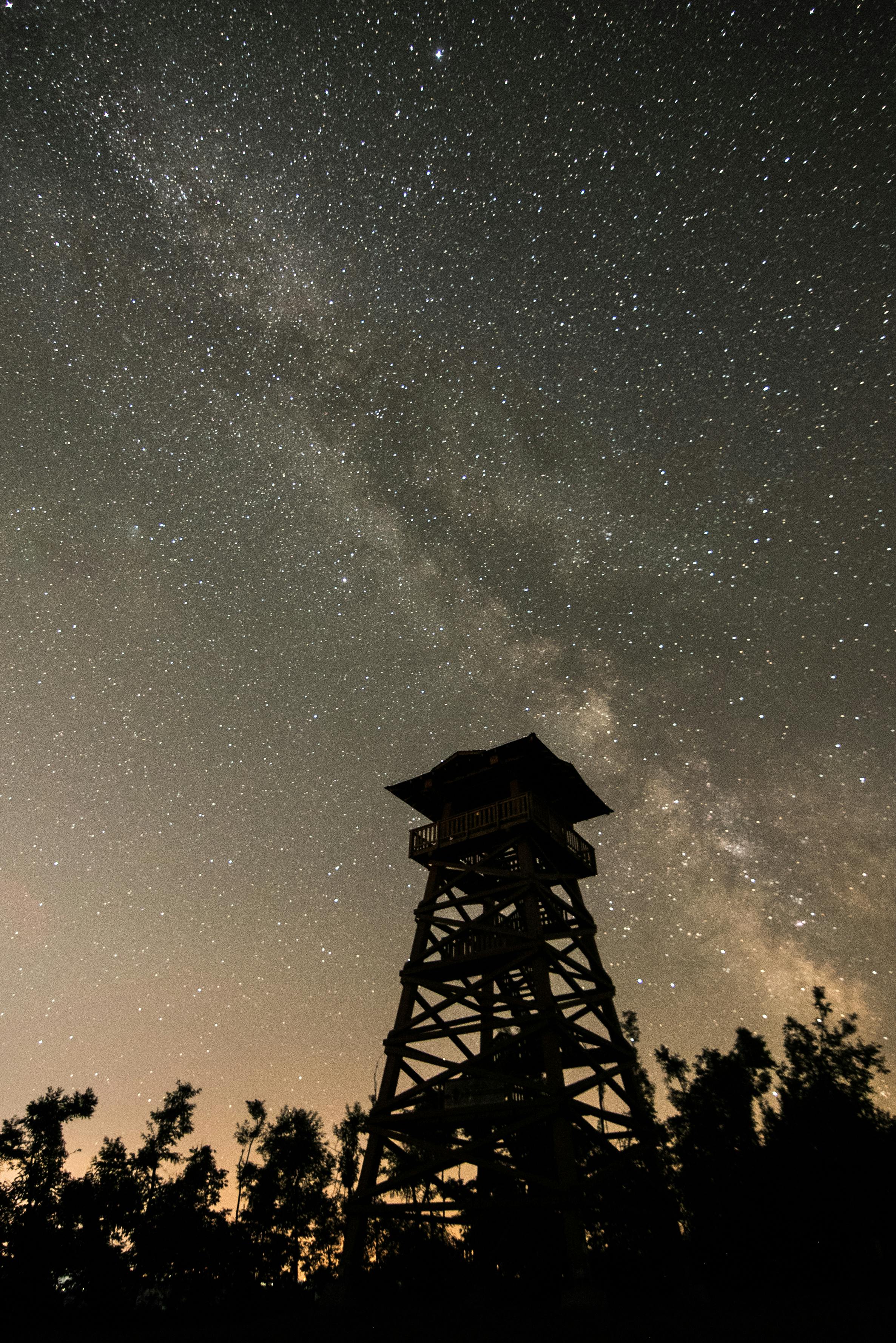 silhouette of observation tower on starry night sky