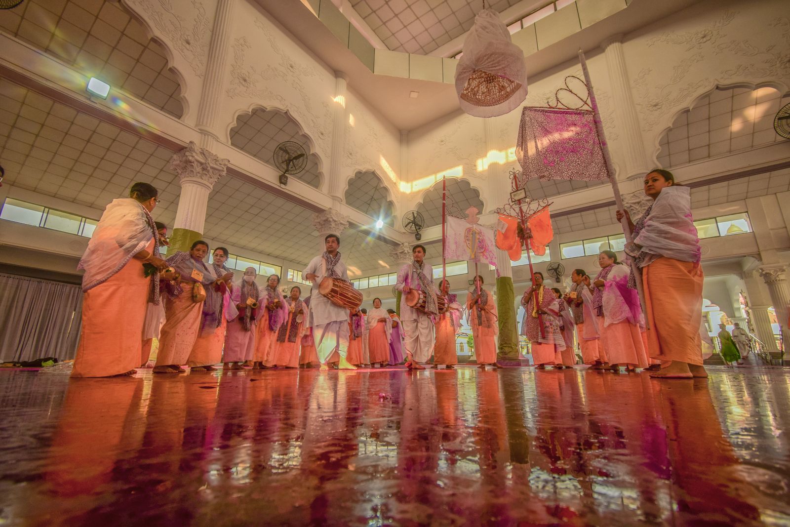 A group of dancers in traditional Indian attire performing in an Indian temple