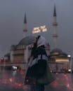 Woman in Hooded Jacket Standing Before Mosque in Istanbul