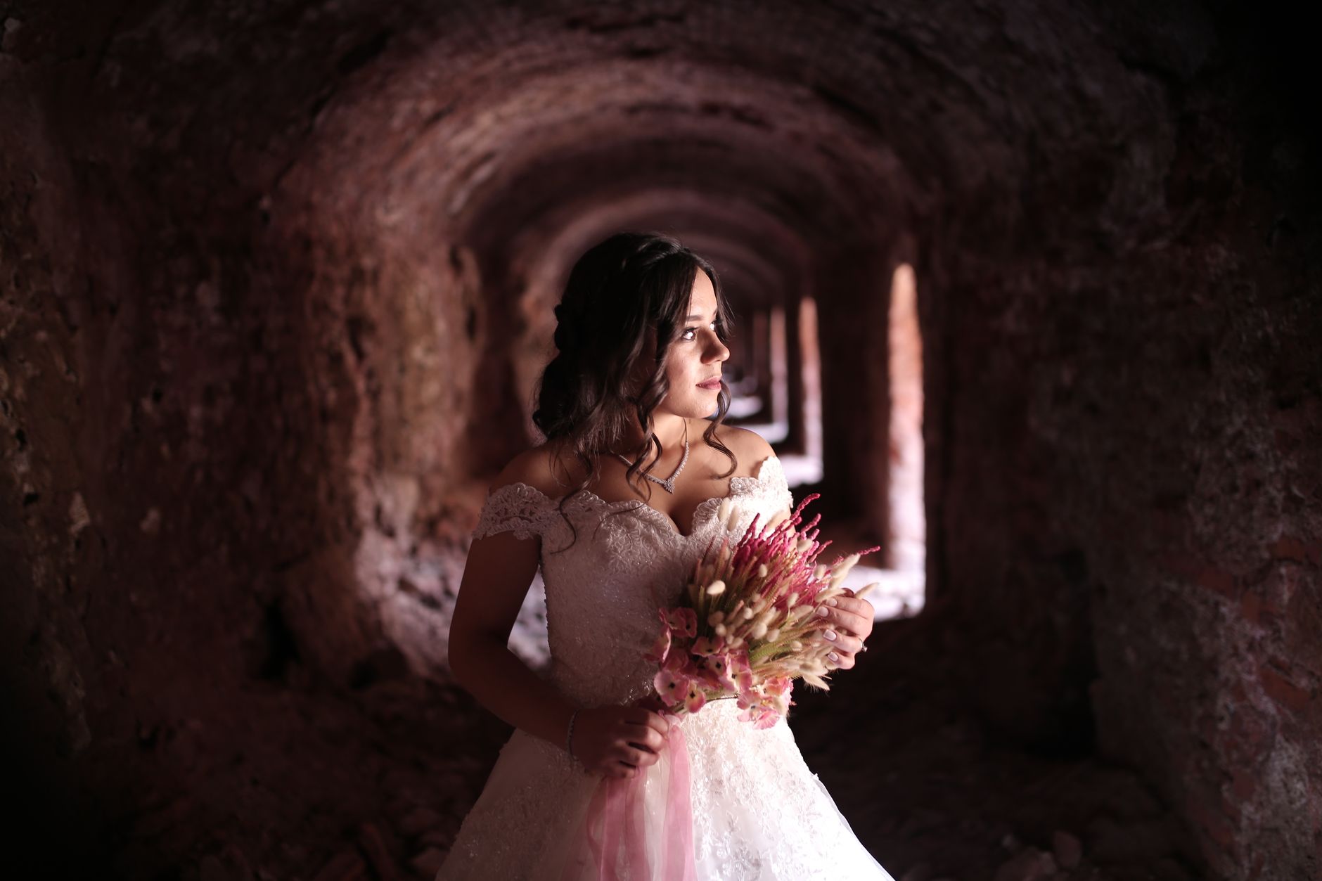 Standar Pelayanan dan Komitmen Kualitas dalam Setiap Paket Wedding Jagarasa 3 Beautiful bride in elegant gown holding floral bouquet, captured in a moody tunnel setting.