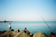 Man in White Shirt Fishing on Sea