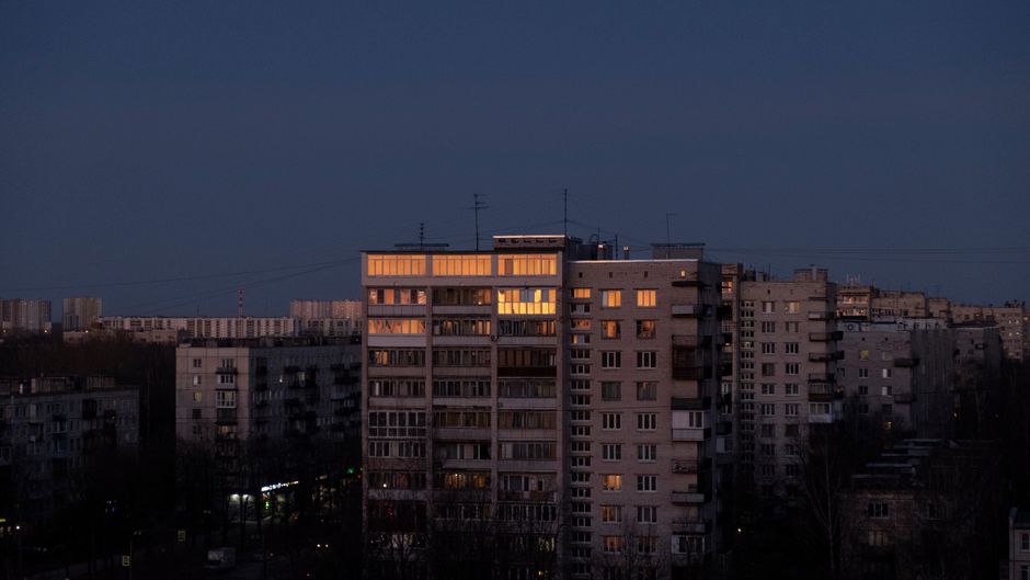 Blok mieszkalny przy ruchliwej ulicy widziany nocą
