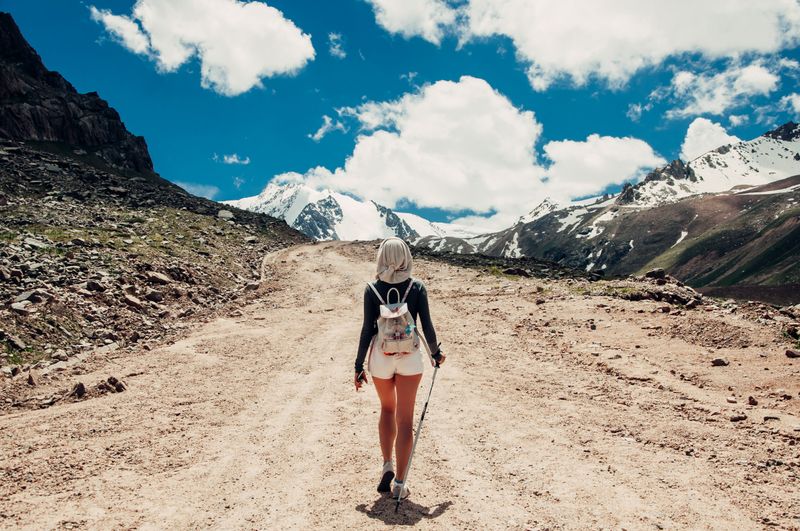 Woman hiking on a mountain trail with a backpack and scenic valley view