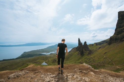 Free A person hiking near the iconic Old Man of Storr rock formation in Scotland's stunning Highlands. Stock Photo