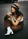 Woman Sitting on a Street with a Burned Out Sparkler