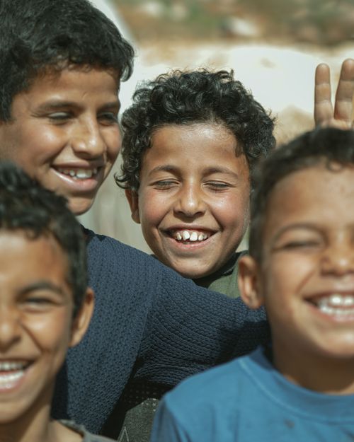 Free A group of boys happily smiling and enjoying a sunny day outdoors in Syria. Stock Photo
