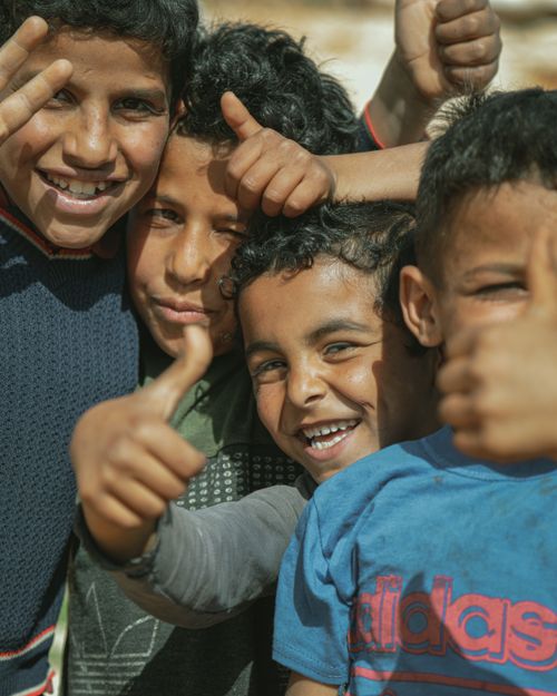 Free A joyful group of boys smiling and showing thumbs up in Idlib, Syria. Stock Photo