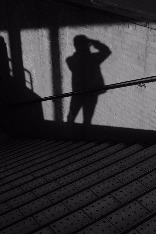 Free Black and white silhouette of a person on brick wall near stairs. Stock Photo