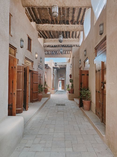 Free Charming traditional alley with wooden doors and plants in a Middle Eastern setting. Stock Photo
