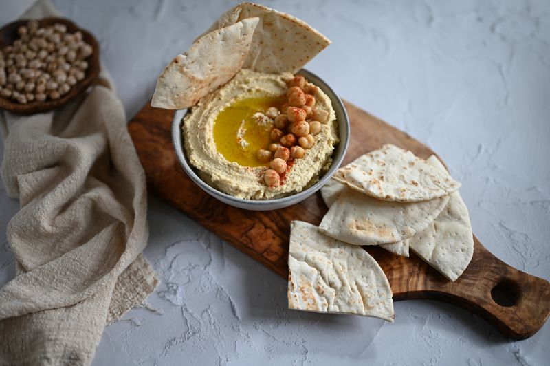 small snack board with hummus, olives, and feta cubes