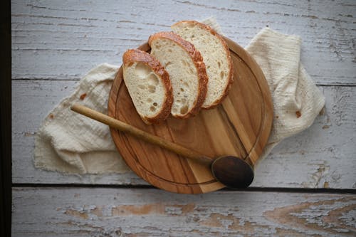 Free Sliced Bread on Brown Wooden Round Plate Stock Photo