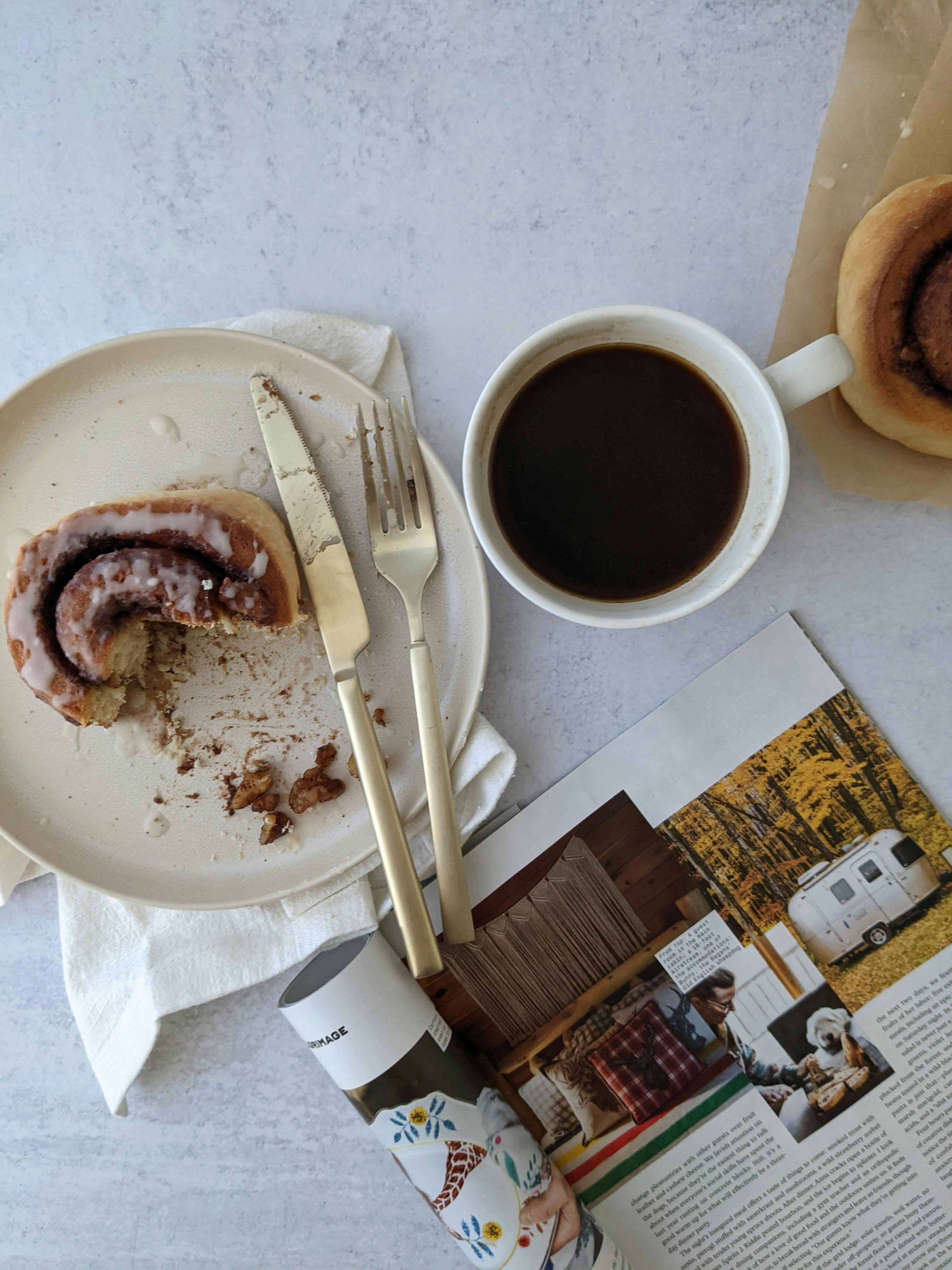 Cinnamon Roll Near the Cup of Coffee · Free Stock Photo