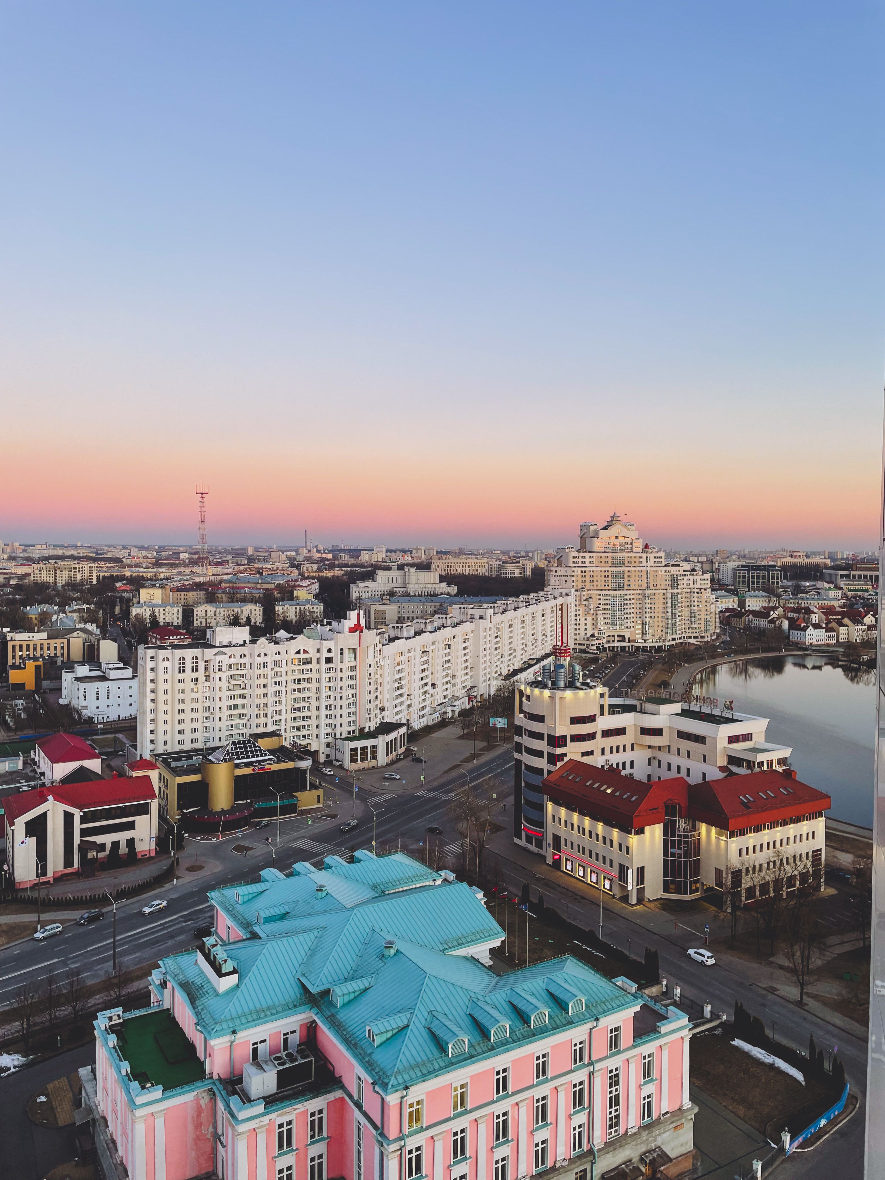 A colorful cityscape view of urban architecture against a beautiful sunset sky.
