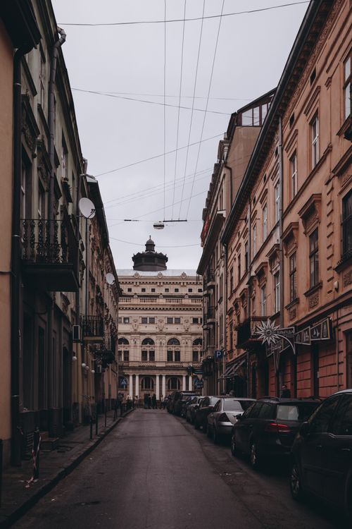 Free A narrow urban street lined with historic buildings and a landmark in the distance. Stock Photo