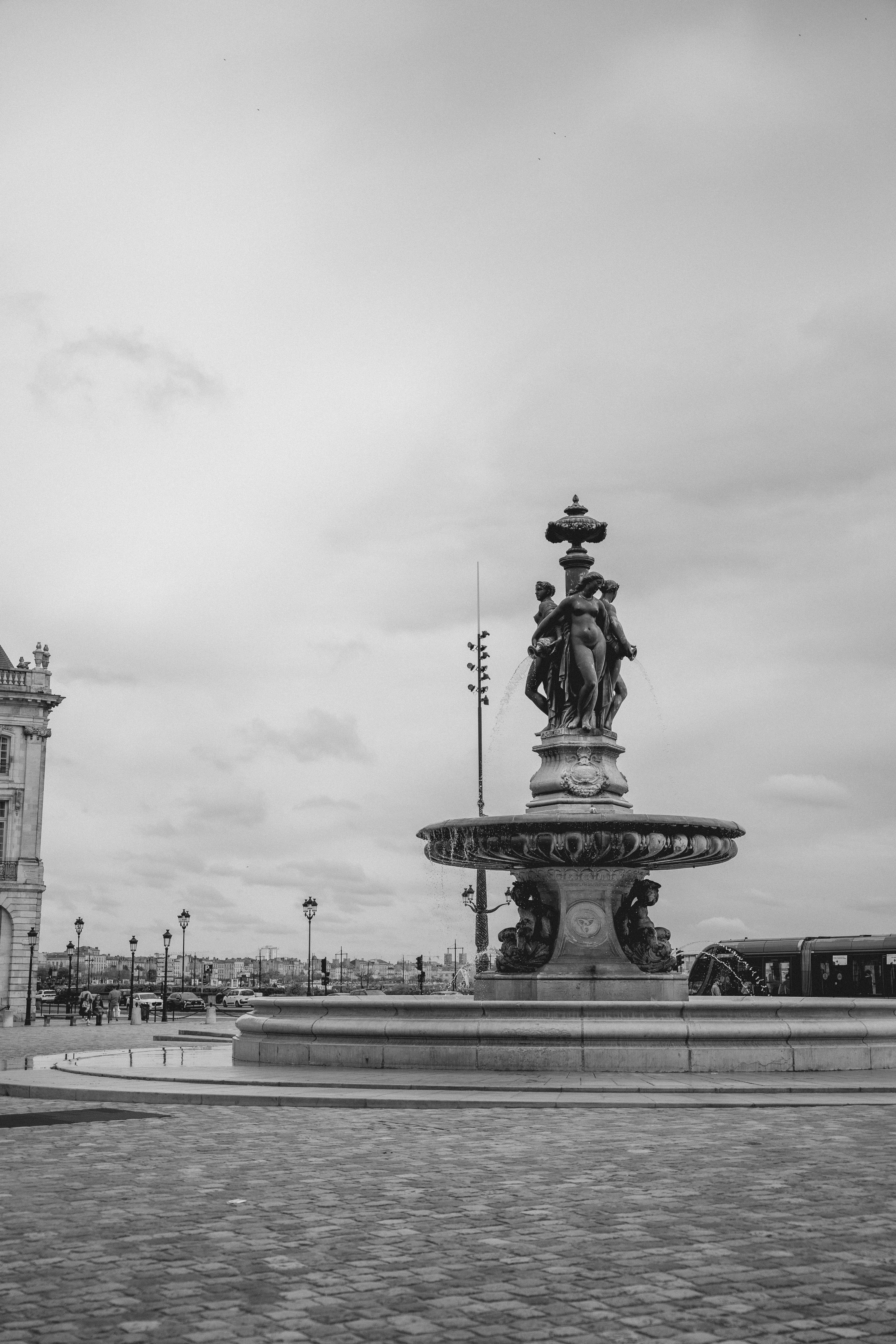 Monochrome image of a historic fountain in Bordeaux, France, featuring classical sculptures.