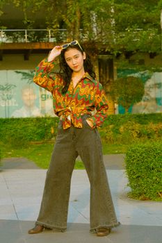 Woman posing outdoors in a colorful retro outfit, exuding confidence and style. Perfect for fashion and lifestyle imagery.