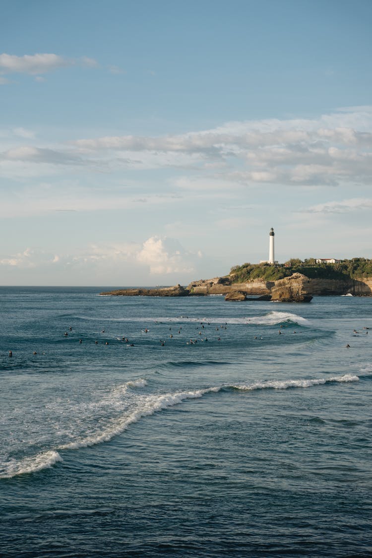 Lone Lighthouse On Shore Overlooking Sea