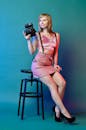Woman in Pink Dress Holding Black Camera
