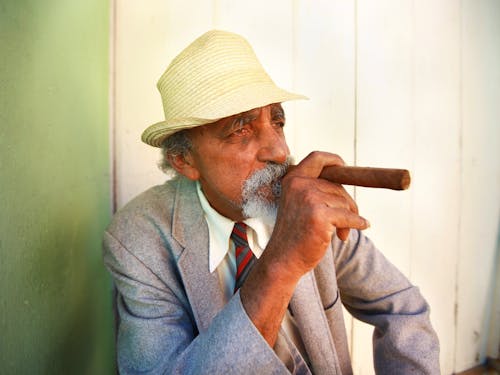 Free Man Wearing Hat while Holding Cigar Stock Photo