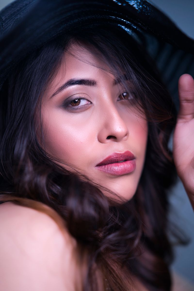 Captivating close-up portrait of a woman in a hat, exuding elegance and style.