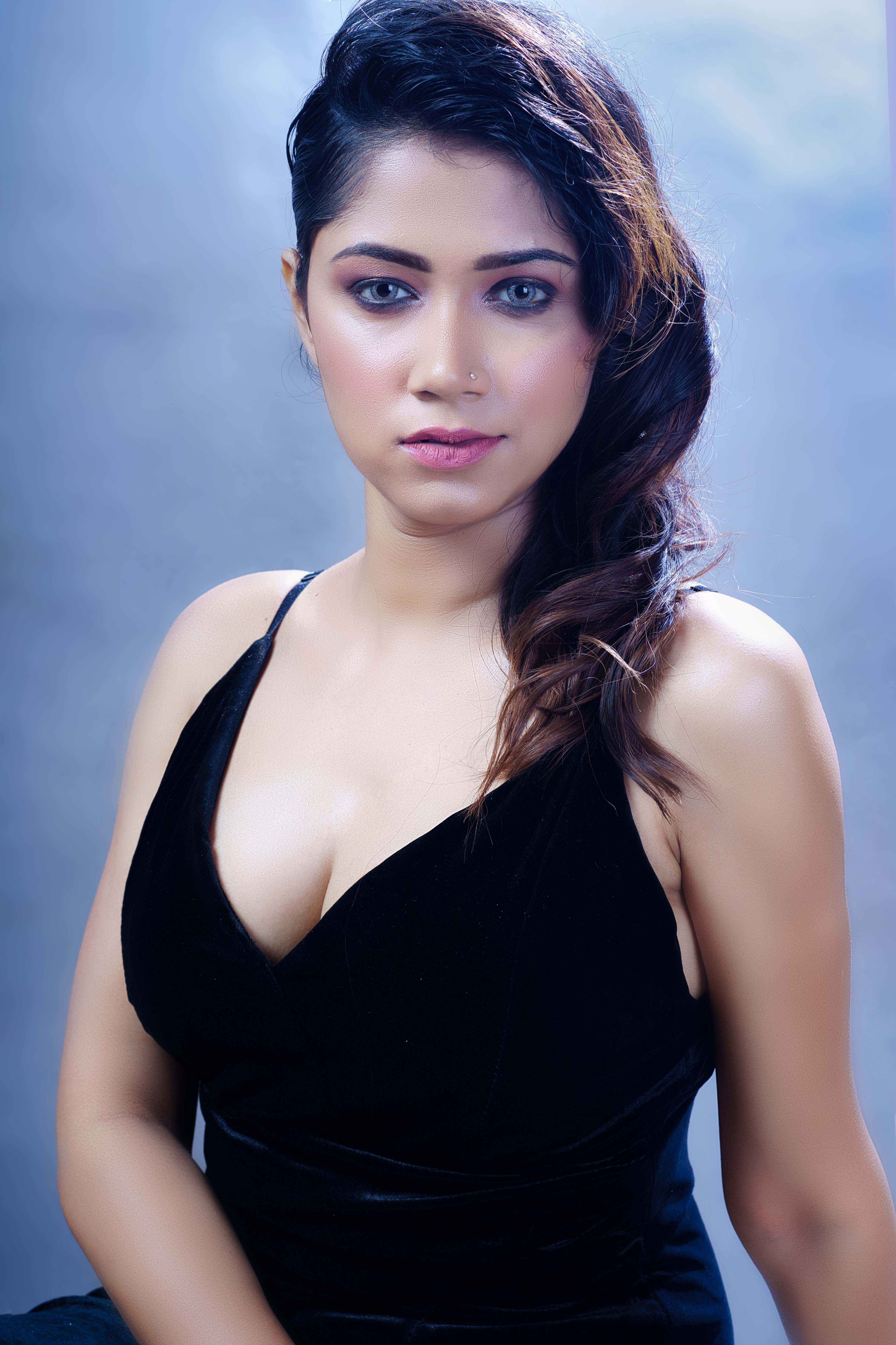 Stunning studio portrait of a woman in a black dress with elegant styling and captivating eyes.