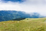 蓝天之下，郁郁葱葱的绿色山脉笼罩在雾中