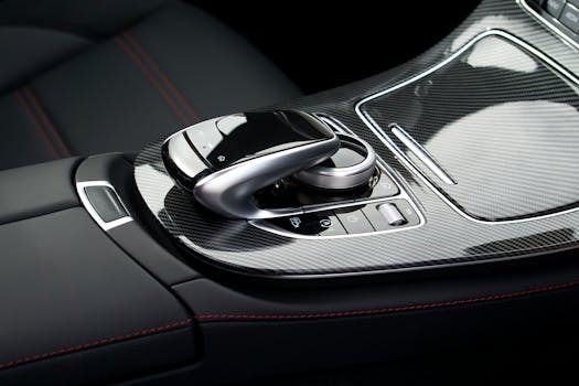Close-up of a luxury car's carbon fiber console featuring sleek design and modern controls.
