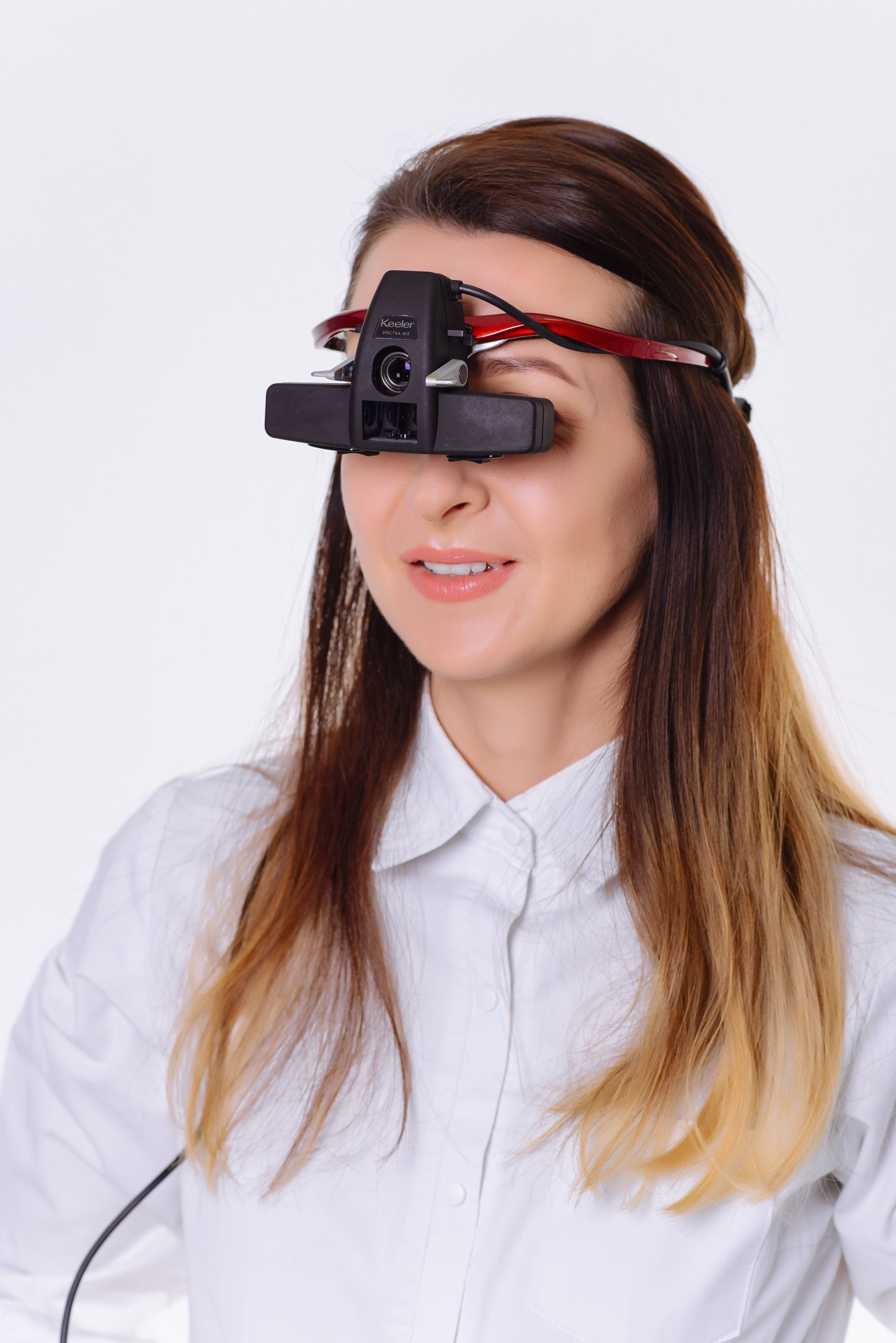 Woman wearing eye examination equipment in a clinical setting. Modern optometry technology.