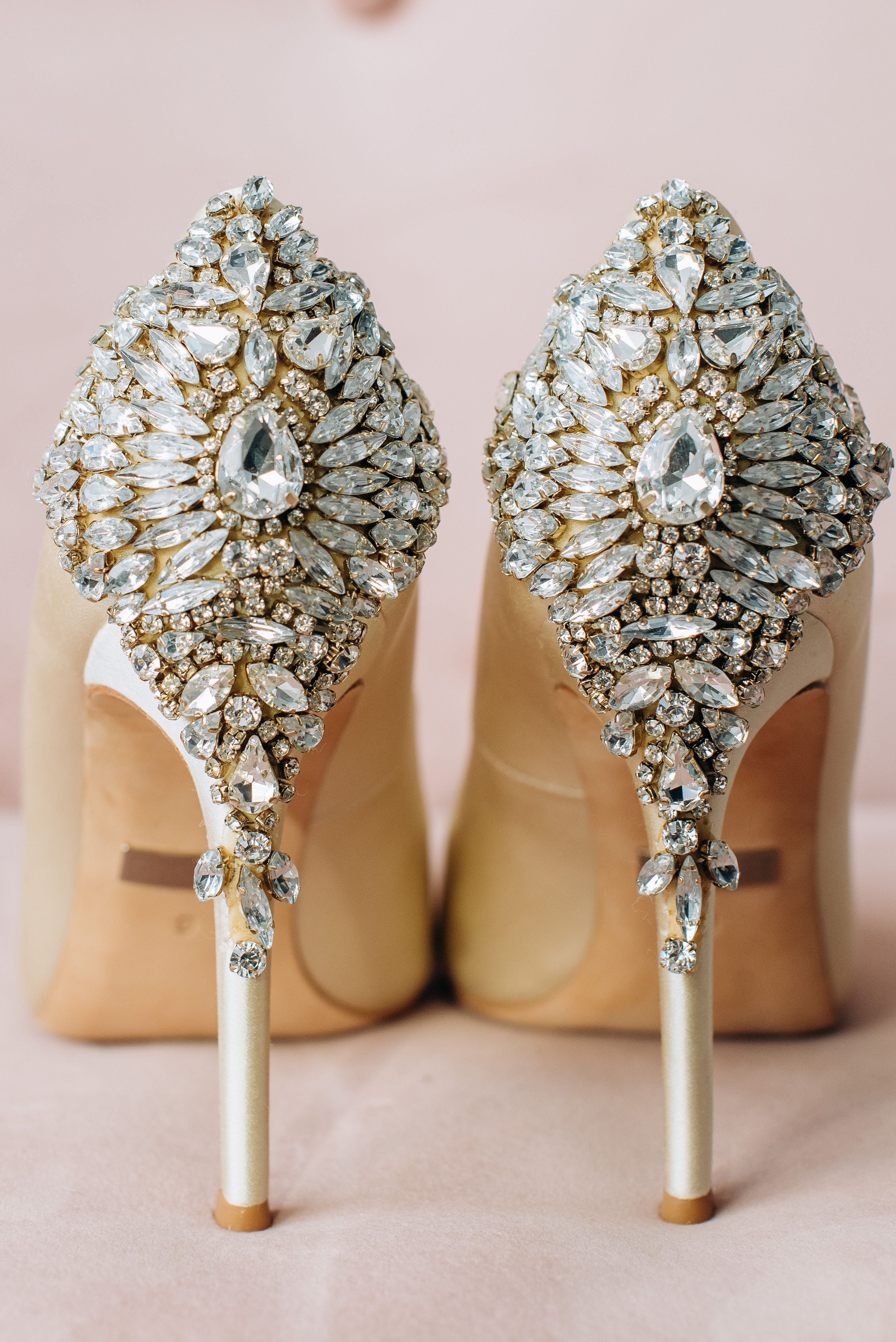 Close-up de sapatos de salto alto cintilantes com decorações de joias ornamentadas, perfeito para uso em editoriais de moda.