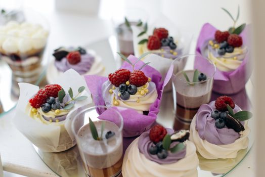 Delicious cupcakes topped with fresh raspberries and blueberries, perfect for dessert lovers.
