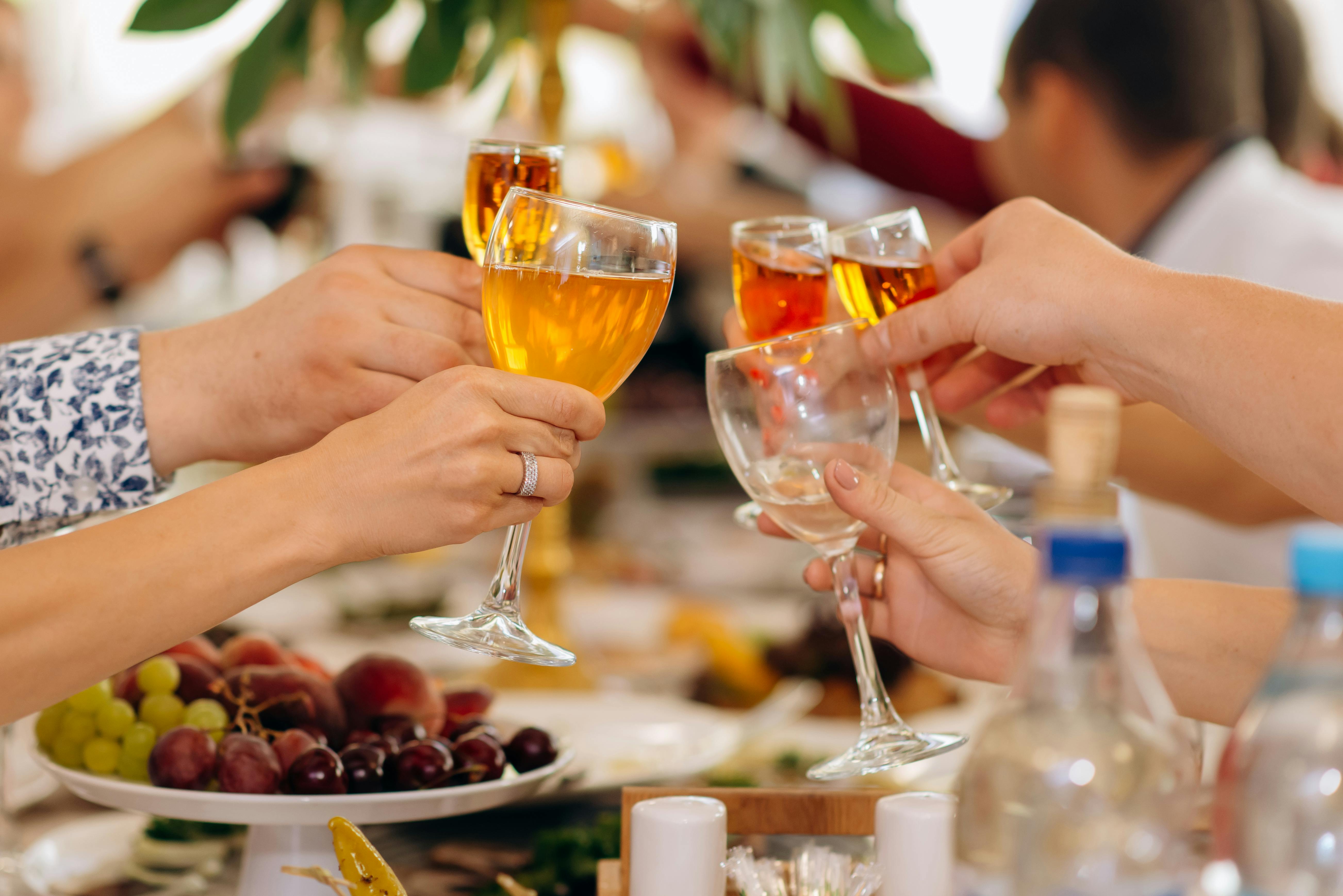 Person holding clear wine glass with red wine photo – Free Cheers