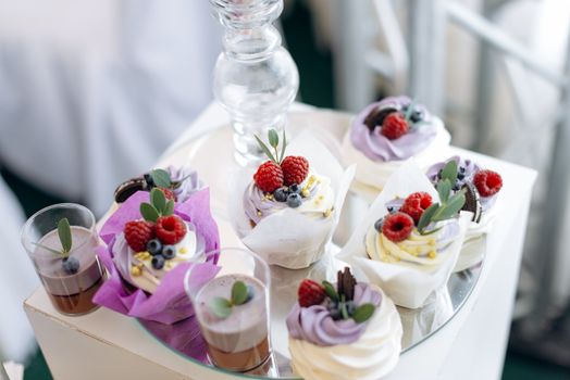 Delicious display of vibrant cupcakes topped with raspberries and blueberries.