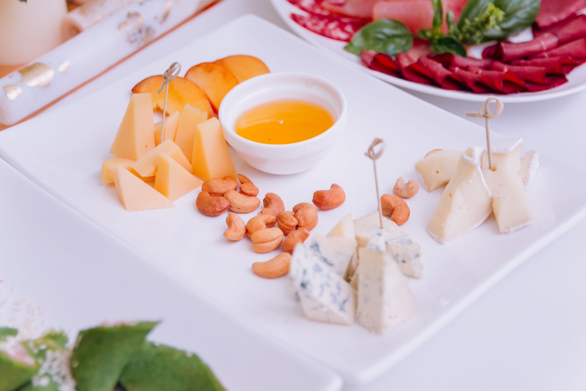 Assorted cheese platter with fresh fruits and nuts, perfect for a celebration.