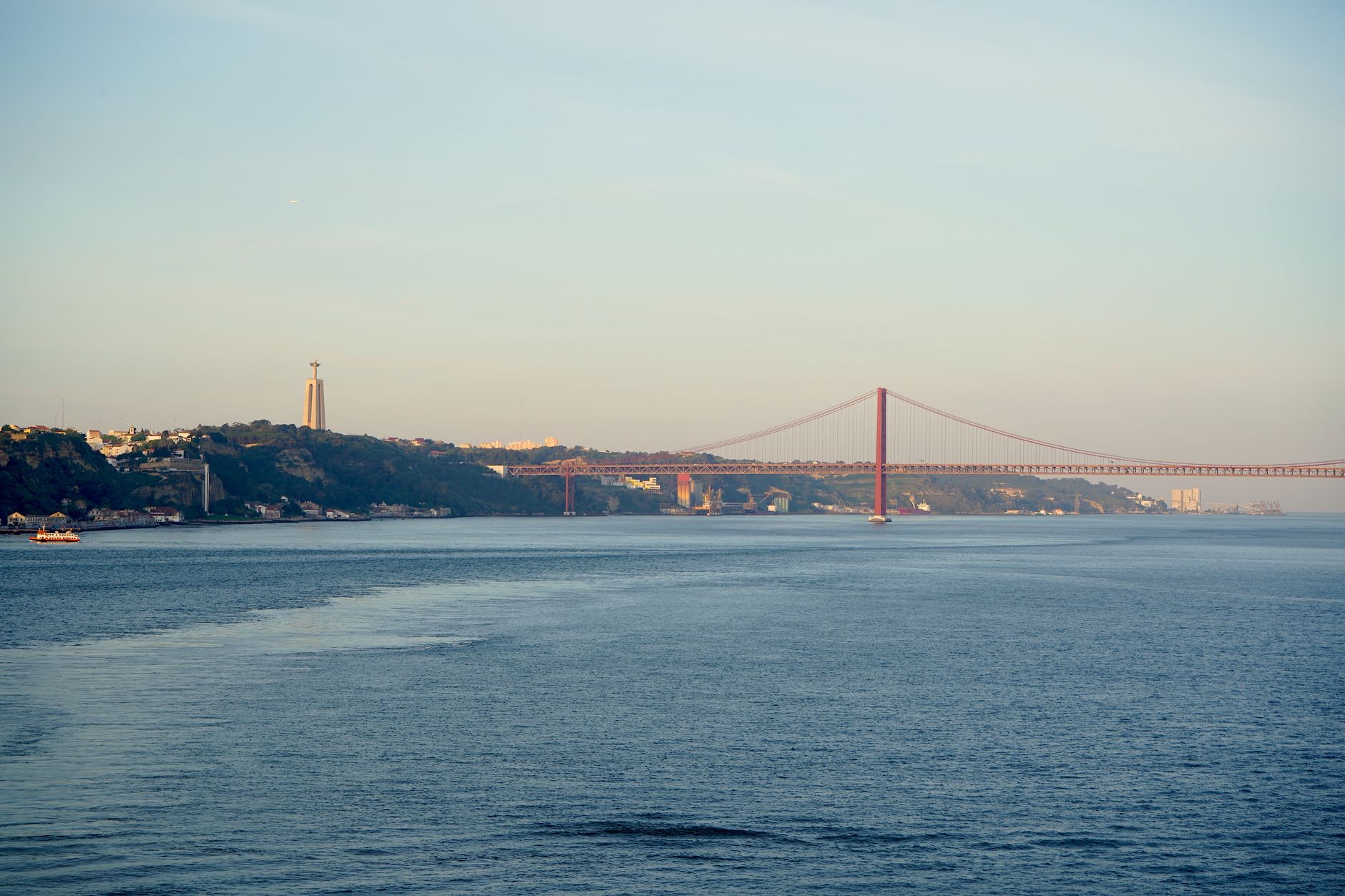 Iconic view of the 25th April Bridge over the Tagus River in Lisbon during daytime.