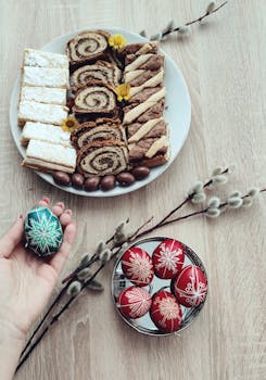 A high-angle shot of Easter pastries and beautifully decorated eggs on a wooden table, perfect for holiday inspirations.