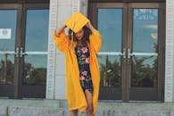 一位年轻女子身穿黄色毕业礼服，在户外庆祝她的学业成就