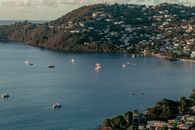 Scenic aerial view of a bay in Grenada with scattered boats and lush hills.