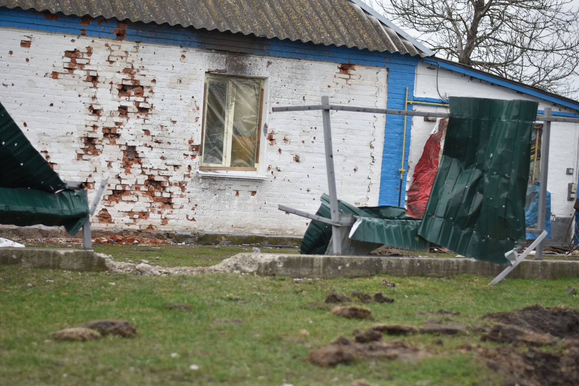 Damaged house exterior with broken wall and fence