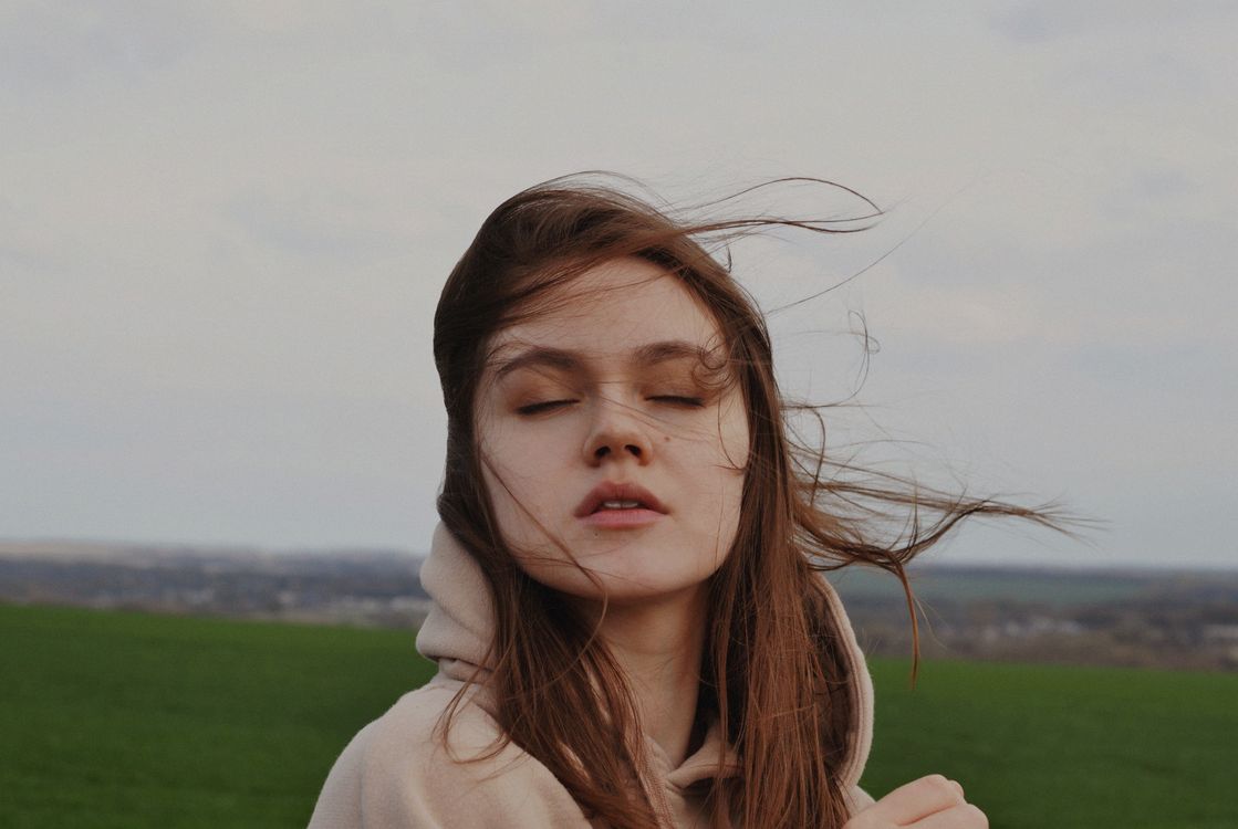Girl in White Hoodie Standing on Green Grass Field · Free Stock Photo