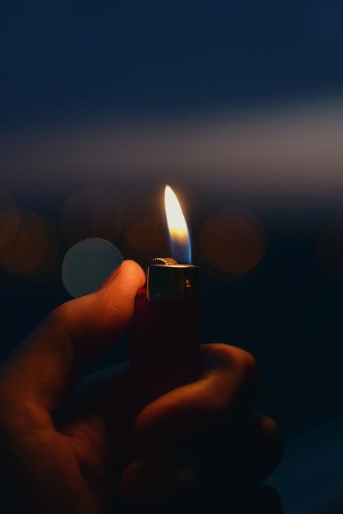 Free A Person Holding a Lighter Stock Photo