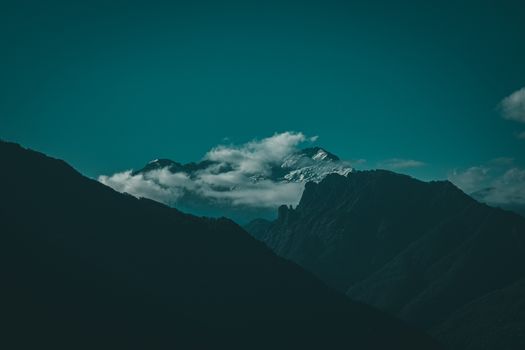 Stunning view of a cloudy mountain peak captured in dramatic lighting.