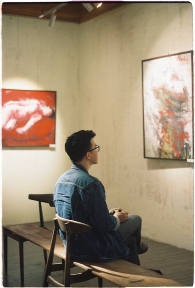 Painter seated in the gallery before a talk