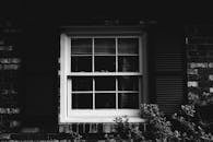 砖墙上的旧窗户和百叶窗，映衬着经典的黑白照片