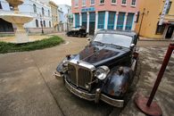 A Black Classic Car Parked on Sidewalk