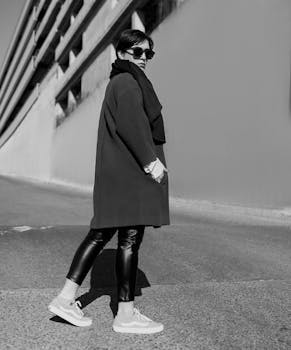 Stylish woman in monochrome attire posing confidently in Tehran's urban landscape.