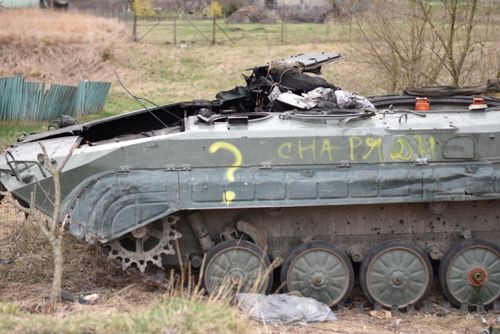 Free A destroyed military tank with graffiti in a rural field setting, suggesting past conflict. Stock Photo